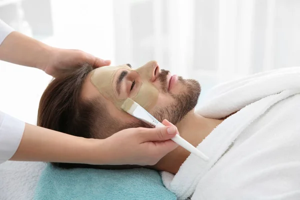 Cosmetologo applicare maschera sul viso del cliente nel salone spa — Foto Stock