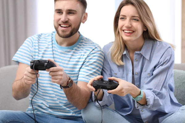 Молодая пара играет в видеоигры дома — стоковое фото