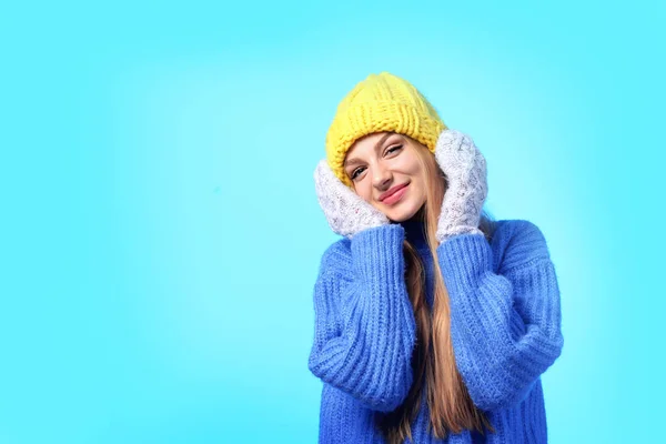 Retrato de jovem mulher emocional em chapéu elegante, suéter e mitenes em fundo de cor, espaço para texto. Ambiente de inverno — Fotografia de Stock