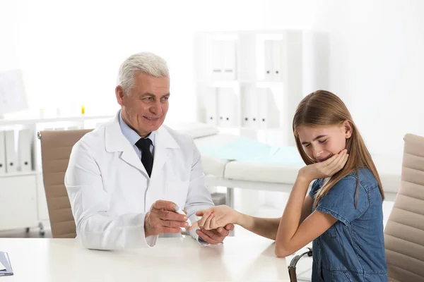 Doctor taking patient's blood sample with lancet pen in hospital. Diabetes control — Stock Photo, Image