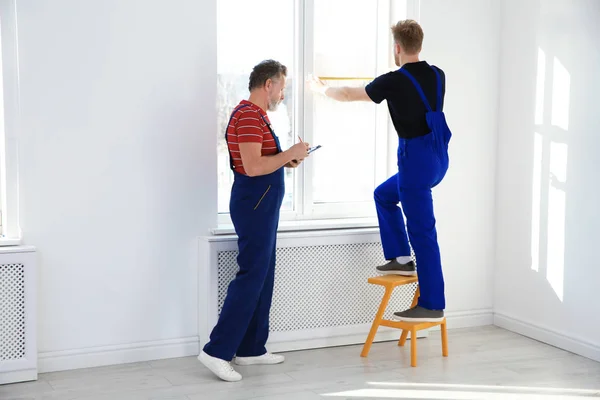 Servicekräfte messen Fenster für den Einbau in Innenräume. Raum für Text — Stockfoto