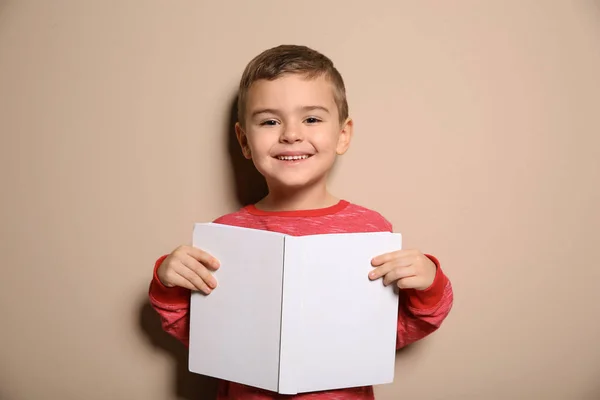 Anak kecil yang lucu dengan buku di latar belakang warna — Stok Foto