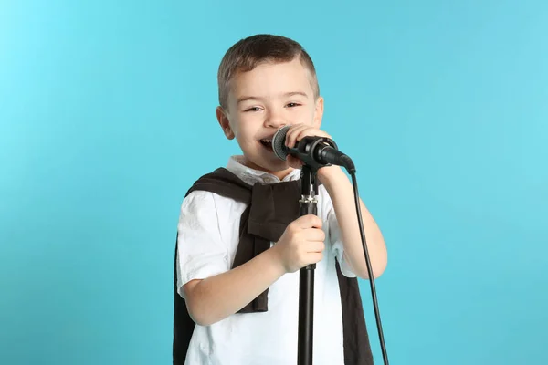 Söt rolig pojke med mikrofon på färgbakgrund — Stockfoto