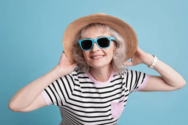 Porträtt av mogen kvinna i hipster outfit på färgbakgrund — Stockfoto