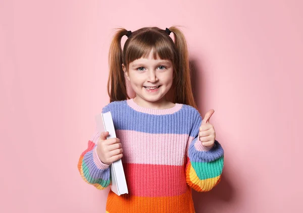 Милая маленькая девочка с книгой на цветном фоне — стоковое фото