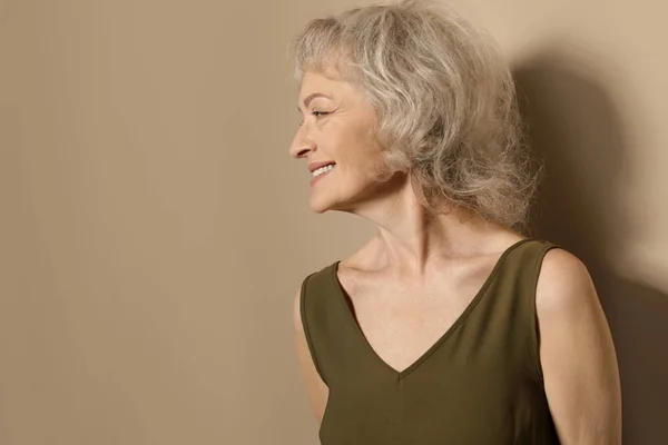 Portret van een volwassen vrouw op kleur achtergrond. Ruimte voor tekst — Stockfoto