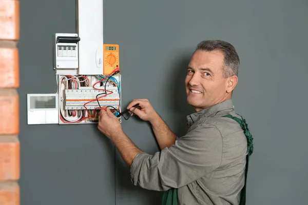 Electricista profesional con voltaje de comprobación del probador en interiores —  Fotos de Stock