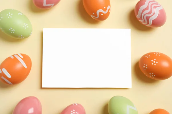 Flat lay composition of painted Easter eggs and blank card on color background, space for text — Stock Photo, Image