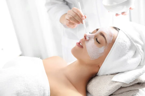 Kosmetolog tillämpa mask på kundens ansikte i spasalong — Stockfoto