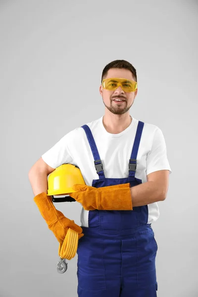 Trabajador industrial masculino en uniforme sobre fondo claro. Equipo de seguridad —  Fotos de Stock