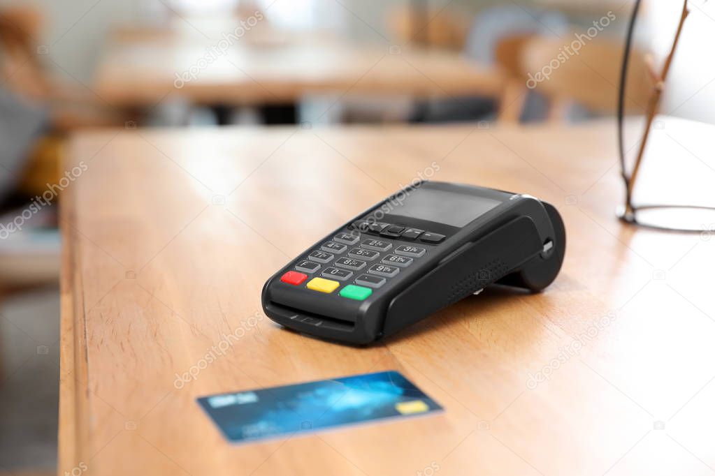 Credit card machine for non cash payment on wooden table indoors
