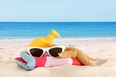 Kumlu deniz kıyısında plaj aksesuarları kümesi