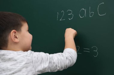 Küçük çocuk matematik toplam kara tahta yazma
