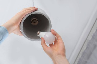 Adam kolye lamba kapalı, closeup ampul değiştirme. Düşük açılı görünüş