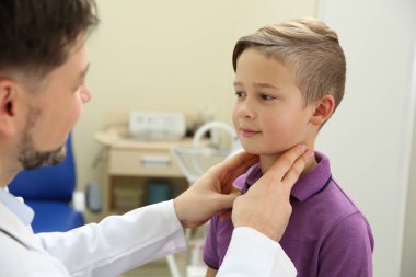 Erkek otolaryngologist küçük çocuğun hastanede incelenmesi