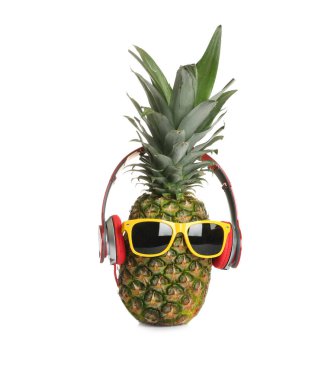 Beyaz arka plan üzerinde güneş gözlüğü ve kulaklık ile komik ananas