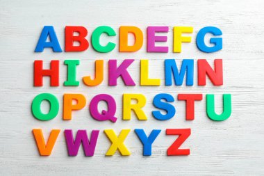 Ahşap arka plan, üstten görünüm plastik manyetik harfler. Alfabetik