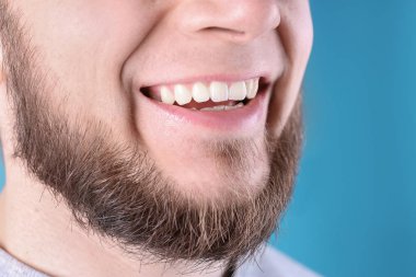 Sağlıklı dişler ve renk arka plan, closeup güzel gülümseme ile genç adam