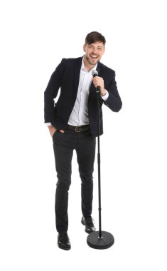 Yakışıklı erkek takım elbise şarkı beyaz arka plan üzerinde mikrofon ile