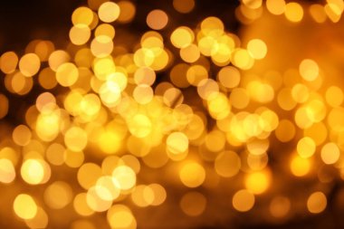 Koyu arka plan üzerinde bokeh etkisi ile altın glitter