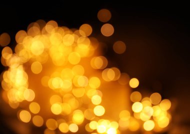 Koyu arka plan üzerinde bokeh etkisi ile altın glitter