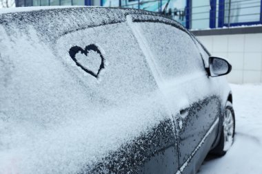 Araba üzerinde çizilmiş kalp açık havada karla kaplı. Metin için yer