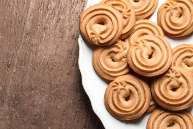 Ahşap arka plan, üstten görünüm üzerinde Danimarka kurabiyeleri plakalı. Metin için yer