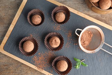 Kurulu ile ahşap arka plan, üstten görünüm üzerinde çikolata truffles