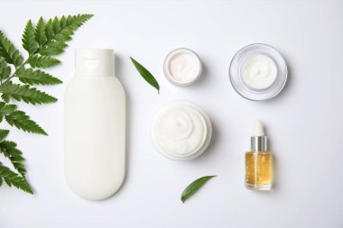 Düz kompozisyon ile farklı vücut bakım ürünleri beyaz arka plan üzerinde yatıyordu