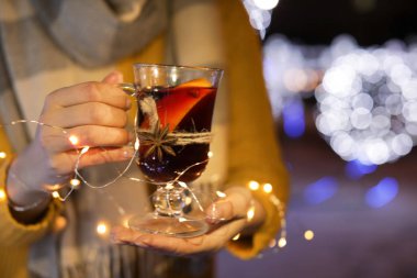 Cam fincan mulled şarap ve garland kış Fuarı, closeup adlı kadınla. Metin için yer
