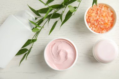 Düz kompozisyon ile farklı vücut bakım ürünleri beyaz ahşap zemin üzerinde yatıyordu