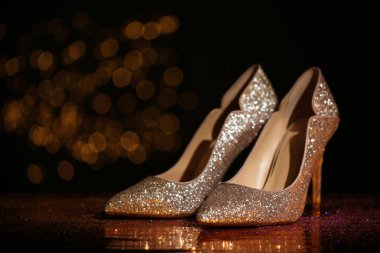 Altın glitter ayakkabı karanlık yansıtıcı yüzeyi arka plan bulanık karşı. Metin için yer