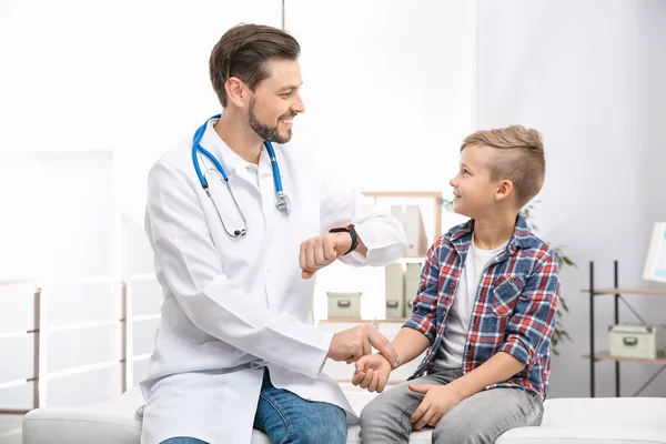 Läkare kontrollera lilla pojkens puls med fingrar på sjukhus — Stockfoto