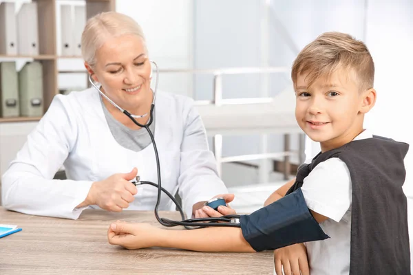 Kleine jongen bezoekende arts in het ziekenhuis. Meten van de bloeddruk en pols controleren — Stockfoto