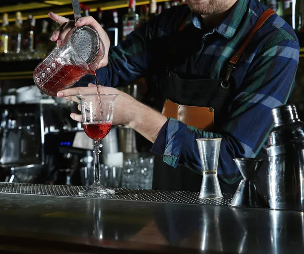 Barman derramando coquetel através de filtro em vidro no balcão no pub, close-up — Fotografia de Stock