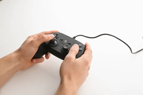 Junger Mann mit Videospielcontroller auf weißem Hintergrund, Nahaufnahme — Stockfoto