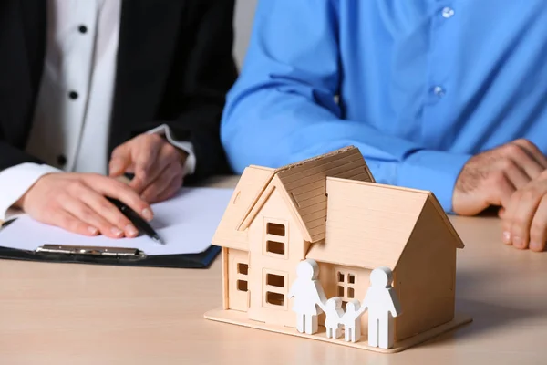 Agente imobiliário trabalhando com o cliente na mesa, foco em figuras da casa e da família. Seguro doméstico — Fotografia de Stock