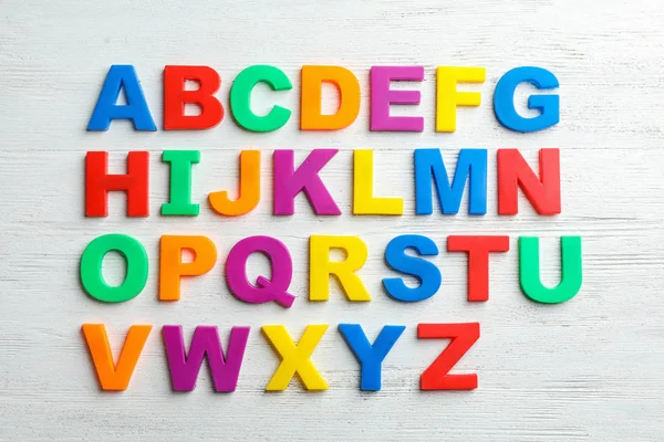 Plastic magnetic letters on wooden background, top view. Alphabetical order — Stock Photo, Image