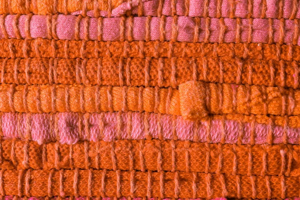 Textuur van gebreide oranje en roze stof als achtergrond, close-up — Stockfoto