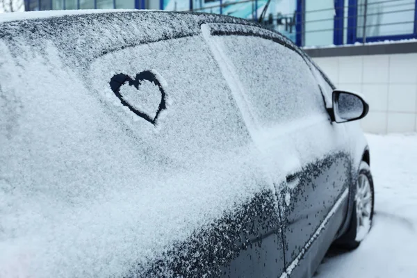 Heart drawn on car covered with snow outdoors. Space for text