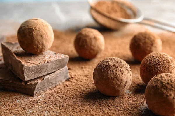 Сладкие сырые шоколадные трюфели с какао на столе — стоковое фото