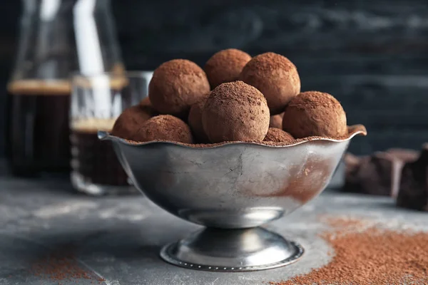 Чаша с вкусными шоколадными трюфелями на сером столе — стоковое фото