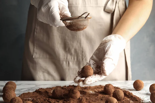 Kadın masada, closeup lezzetli çikolata truffles hazırlanması — Stok fotoğraf