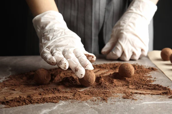 Mujer preparando sabrosas trufas de chocolate en la mesa, primer plano —  Fotos de Stock