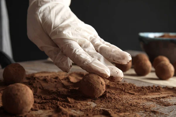 Kadın masada, closeup lezzetli çikolata truffles hazırlanması — Stok fotoğraf