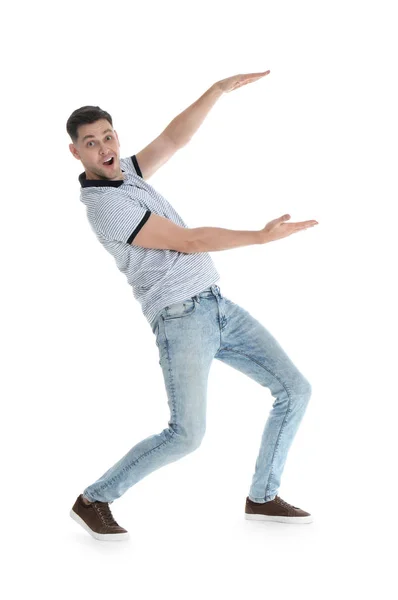 Emocional hombre en ropa casual sosteniendo algo sobre fondo blanco — Foto de Stock