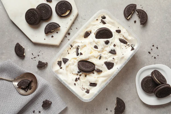 Composição plana com recipiente de sorvete e biscoitos de chocolate em fundo cinza — Fotografia de Stock