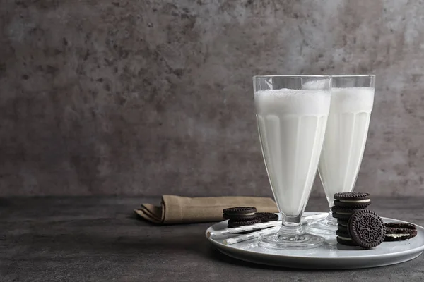 Gelas susu dengan kue coklat di atas meja dengan latar belakang abu-abu, ruang untuk teks — Stok Foto