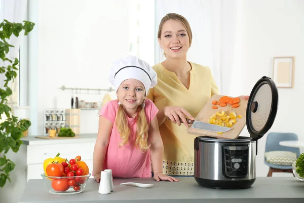 Madre e figlia preparare il cibo con moderno multi fornello in cucina — Foto Stock