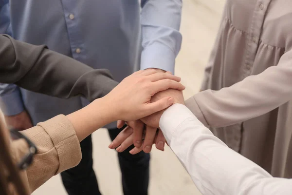 Groupe de personnes tenant leurs mains ensemble sur fond flou, gros plan — Photo